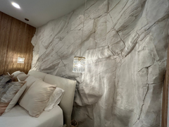 A Bedroom With White Bed and Covers. Behind the Bed, The Large White Andes Panel Covers the Wall