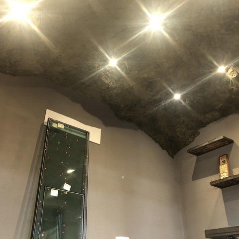 A Ceiling covered with the Crystal Rock Panel. 5 equidistant pot light LEDS are attached through the panel, shining brightly