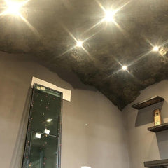 A Ceiling covered with the Crystal Rock Panel. 5 equidistant pot light LEDS are attached through the panel, shining brightly