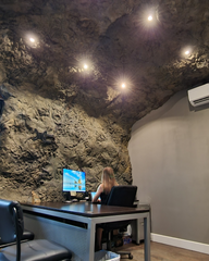 A Large Desk in an office, on the Ceiling and the Wall behind, The Crystal Rock Panel is Mounted