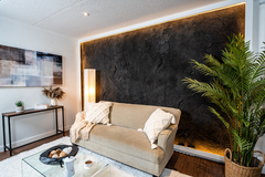 A Living room with a beige Couch. The Wall behind the couch is coverd with a Dragonstone Panel