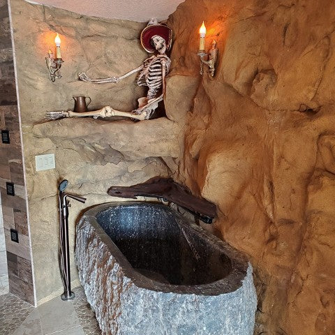 Malawi Panel Mounted in Bathroom Corner over Bathtub, with a skeleton nested on panel ledge above bathtub.