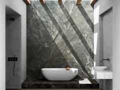 A Modern Bathtub sitting on a stone pedestal. Behind, the Slate Wall Panel Covers the Wall